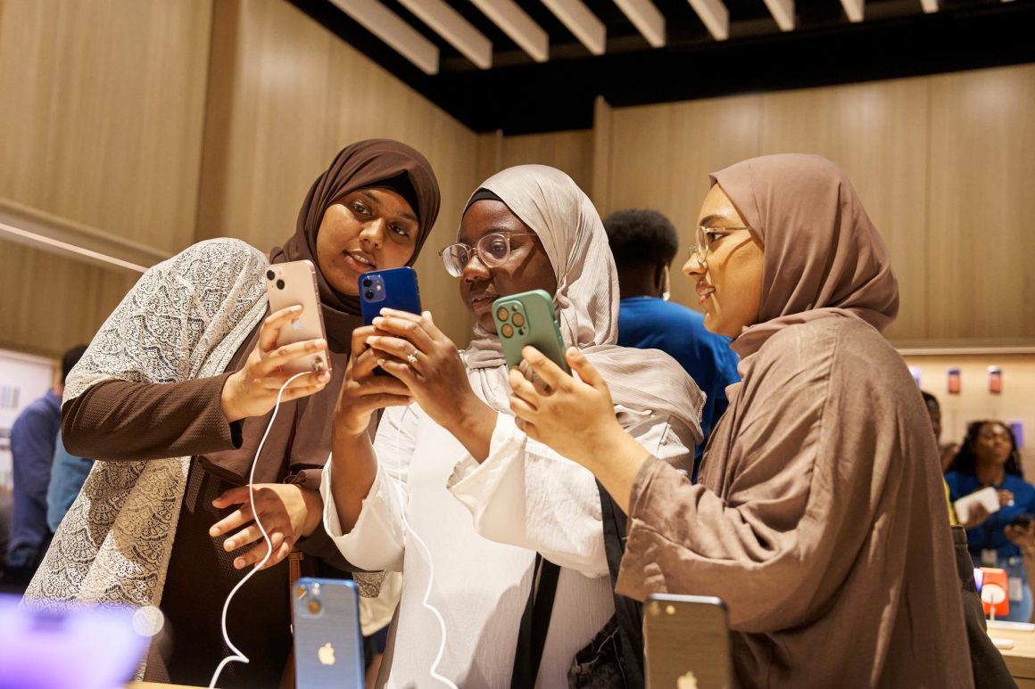 Customers explore the iPhone 14 lineup at Apple Battersea in London.